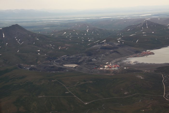 Luftbild einer kargen Landschaft mit einigen Schneeflecken; im Mittelpunkt des Fotos eine industrielle Anlage