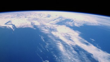 Luftbild: Dünnes Wolkenband über einem Ozean