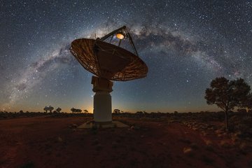 Antennenschüssel eines Radioteleskops unterm Sternenhimmel