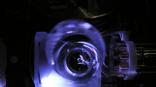 Das Bild zeigt ein Detail einer Atomuhr, die an der Physikalisch-Technischen Bundesanstalt in Braunschweig betrieben wird. Dabei handelt es sich um eine Atomuhr, die mit Ytterbium-Atomen als Taktgeber funktioniert und eine genauere Zeitmessung ermöglicht