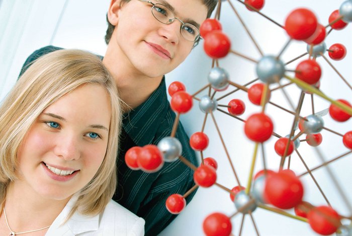 Ein Junge und Mädchen vorm Modell eines Moleküls