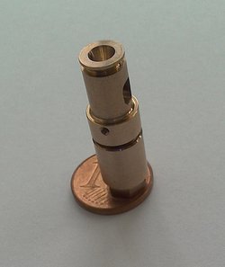 Kleiner Metallzylinder steht auf einem 1-Cent-Stück.