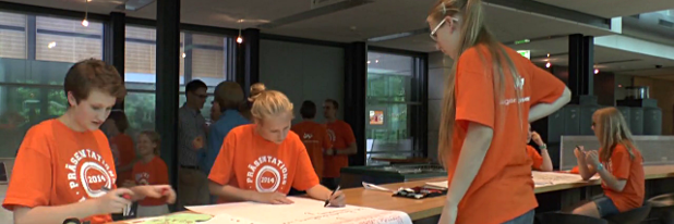 Jugend präsentiert 2014 Mehrere Mädchen in gleichfarbigen T-Shirts arbeiten gemeinsam konzentriert an Präsentationsmaterial wie Postern und Karten
