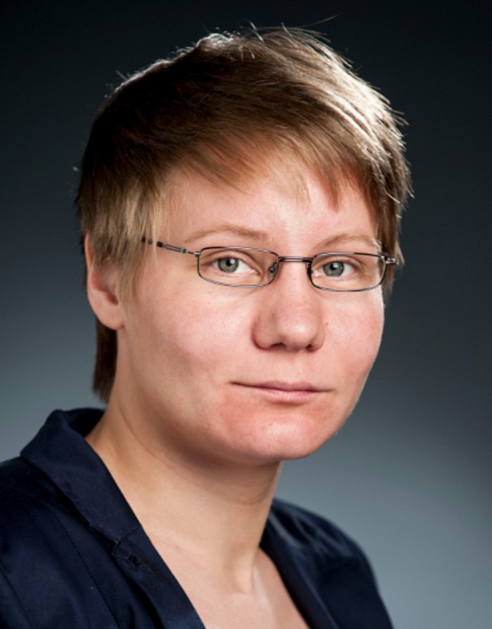 Iris Gebauer Eine jüngere Frau mit kurzen Haaren und einer Brille.