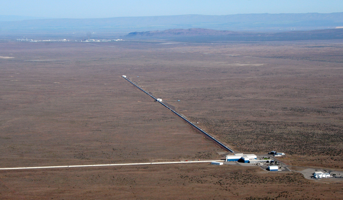 Advanced-LIGO-Detektor Aufnahme von oben zeigt eine karge Landschaft, in der zwei Röhren von einer Anlage abgehen.