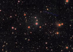 Aufnahme zahlreicher Sterne und Galaxien im Weltall: Schwarzer Hintergrund und viele sehr kleine und größere kreisförmige oder elliptische helle Flecken.