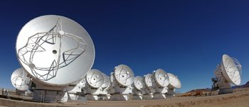 Zahllose weiße Teleskopschüsseln in der Wüste vor blauem Himmel