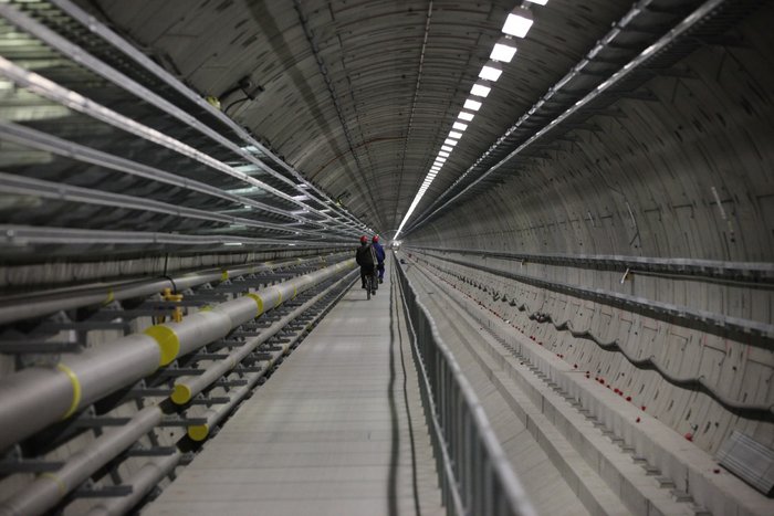 Tunnel für European XFEL Blick in einen langen Tunnel, der bis auf einige Röhren und Balken an den Wänden noch leer ist.