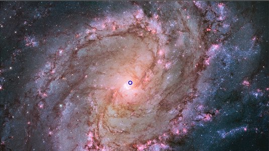 Spiralgalaxie, nahe dem Mittelpunkt befindet sich eine kleine kreisförmige Markierung.