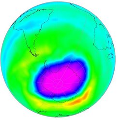 Grafik der Erdkugel mit Fokus auf die südliche Hemisphäre. Ein Großteil der Südhalbkugel ist grün und gelb eingefärbt, was auf ene normale Konzentration von Ozon in der Stratosphäre hinweist. Direkt über der Antarktis ist ein großer, bläulich-violetter Fleck zu sehen, das Ozonloch.