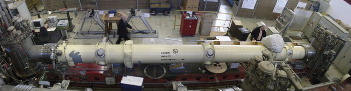 Foto einer neun Meter langen Röhre von etwa einem halben Meter Durchmesser, an der weitere technische Apparaturen angeschlossen sind.