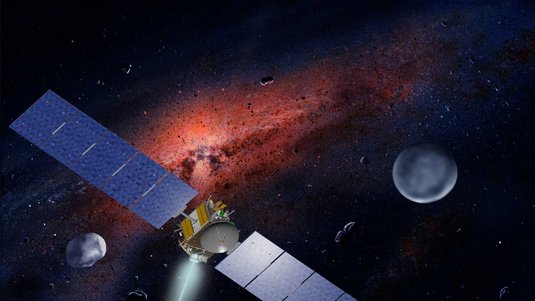 Künstlerische Darstellung: Raumsonde mit ausgefahrenen Solarzellen im All zwischen kleinen Asteroiden vor rot leuchtender Staubwolke