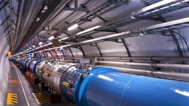 Blick auf den LHC-Beschleuniger, Bildquelle: CERN; Lizenz: gemäß den Bedingungen der Quelle Ein langgezogenes Rohr mit vielen Anschlüssen von etwa einem Meter Durchmesser in einem leicht gekrümmten Tunnel.