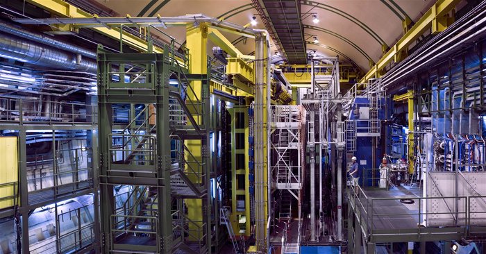 Das LHCb-Experiment im Frühjahr 2008 Foto einer großen unterirdischen Halle mit zahlreichen technischen Komponenten, die zu einem zehn Meter hohen Detektor zusammengesetzt werden.