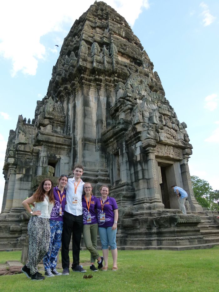 Vier Schülerinnen und ein Schüler vor einem großen, hügelförmigen Tempel.