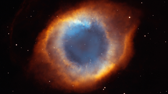 Das Bild zeigt eine ringförmige Gaswolke und viele Sterne.
