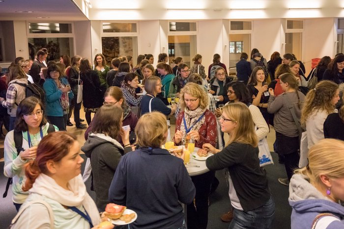 Netzwerken auf 20. Physikerinnentagung Frauen stehen in einem Raum und diskutieren.