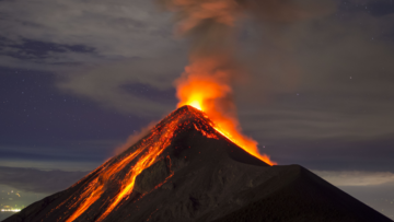 Foto eines Vulkanausbruchs, glühende Lava fließt am Vulkankegel hinunter 