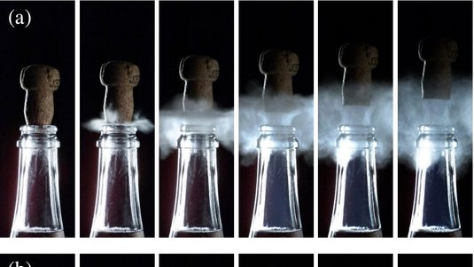 Fünf Bilder zeigen wie ein Champagnerkorken aus einer Flasche fliegt und dabei unterhalb des Korkens blauer Nebel entsteht.