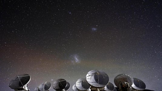 Viele Radioteleskope vor Sternenhimmel