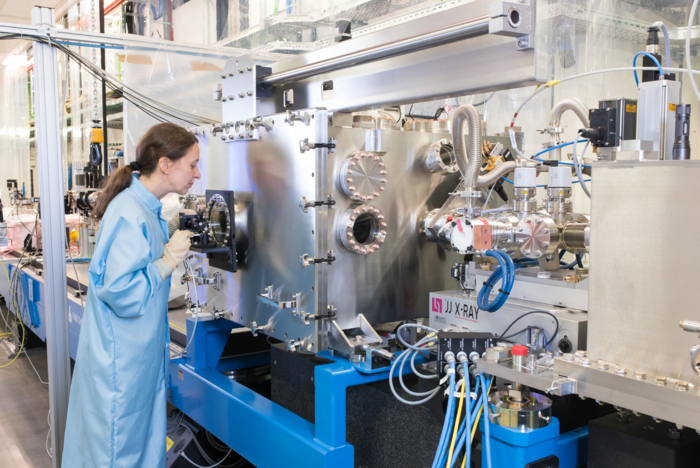 Experiment am European XFEL Auf dem Bild ist eine Forscherin zu sehen, die an einem Teilexperiment arbeitet. Das Experiement befindet sich in einer Metallbox.