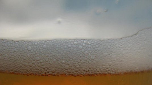 Foto von einem Bier mit Schaumkrone in einem Glas