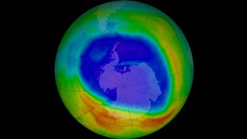 Grafik der Erde: Über der Antarktis breitet sich in der grün dargestellten Erdatmosphäre eine große blaue Fläche aus