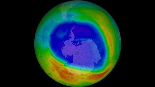 Grafik der Erde: Über der Antarktis breitet sich in der grün dargestellten Erdatmosphäre eine große blaue Fläche aus