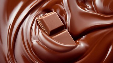 Ein Stück Schokolade in einem Strudel aus flüssiger Schokolade