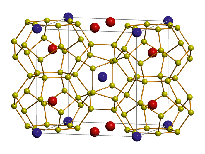Atomarer Aufbau eines thermoelektrischen Materials Kleine und große Kugeln in drei verschiedenen Farben sind in einem Quader in einer periodischen Struktur angeordnet.