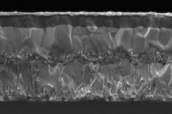 Die aufnahme zeigt eine Mikroskopaufnahme der vielen Schichten der neuen Perowskit-Solarzelle auf einem Glasträger als ein Schnitt durch die Zelle hindurch.