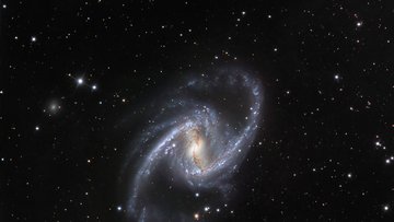 Spiralförmige Galaxie vor schwarzem Hintergrund.