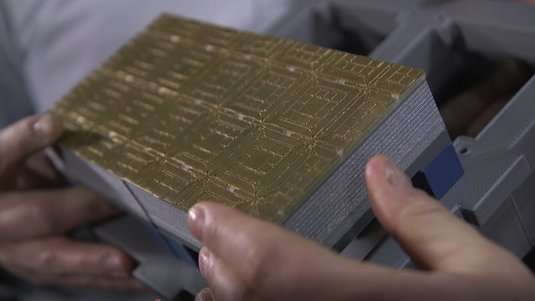 Jemand hält das 3D-Druck Modell eines Quantencomputermoduls in den Händen.