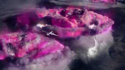 Flugzeug über leuchtenden Gewitterwolken am Nachthimmel