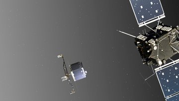 Rechts ein Raumfahrzeug mit großen Solarpanels, in der Mitte ein kleinerer Lander, links die Oberfläche des Kometen.