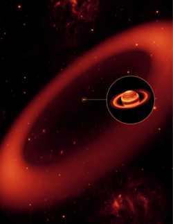 In der Abbildung ist ein ausgedehnter ellipsenförmiger heller Kreis als Saturnring dargestellt, der Planet Saturn ist in einem kleinen Bild vergrößert heraus gezoomt und die vergrößerte Abbildung des kugelförmigen Planeten mit dem Ring außen herum ist in der Mitte rechts über die Ringabbildung gesetzt worden.