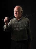 Peter Higgs schreibt Formeln auf eine transparente Tafel.