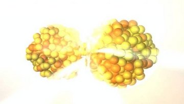 Zwei große Kugeln aus gelbe und orangenen Bausteinen stellen schematisch die Kernspaltung dar.