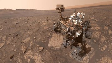 Ein fahrbarer Roboter steht auf der felsigen Marsoberfläche