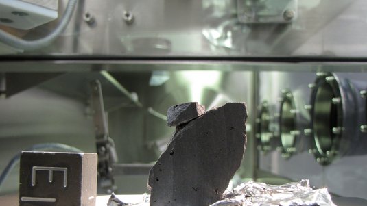 Ein angeschnittener Stein liegt in einer Messapparatur.