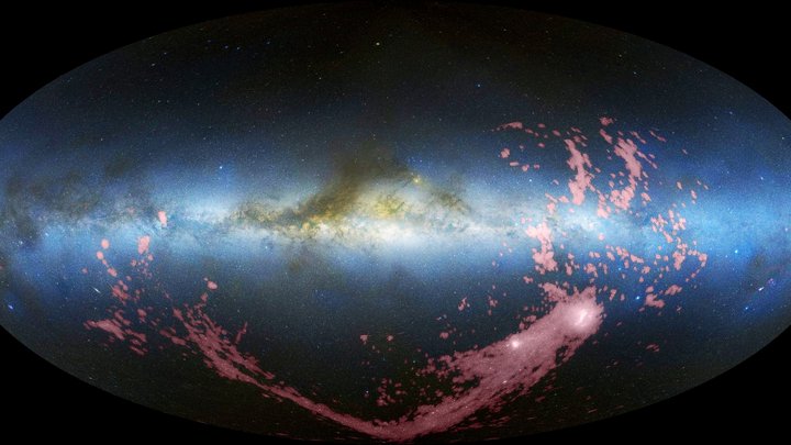 Waagerecht durch das Bild zieht sich die Milchstraße, rechts darunter zwei helle ausgedehnte Objekte, von denen ein langes Band nach links ausgeht.