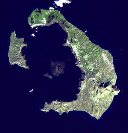 Satellitenbild Inseln von Santorin. Eine große und eine kleine Insel liegen um die Spitze eines Vulkankegels, der nur leicht aus dem Meer ragt.