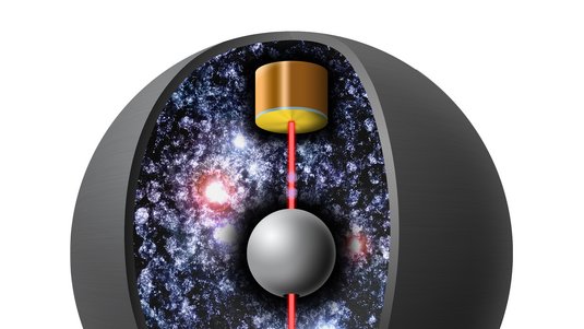 Sphärische Kammer, in der Mitte eine Kugel, darüber zwei violette Punkte. Eine von unten nach oben gehende rote Linie deutet den Laserstrahl an.