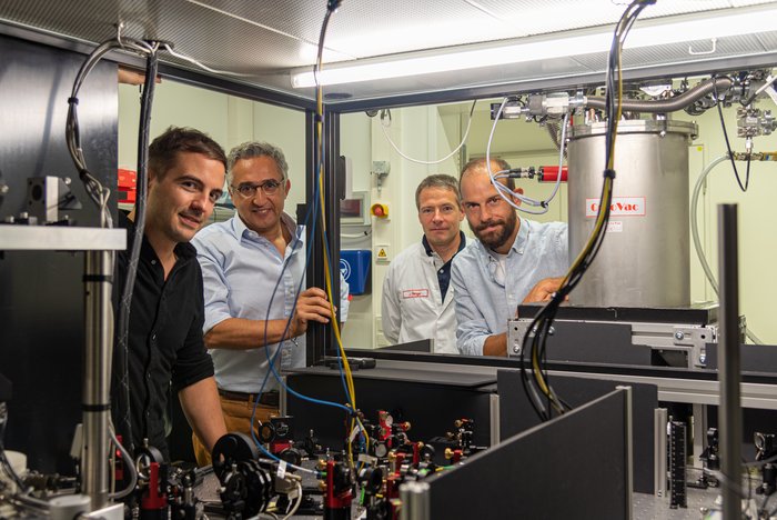 Johannes Zirkelbach und seine Kollegen Vier Männer stehen an einem experimentellen Aufbau mit vielen Spiegeln.
