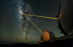 Keck Observatory vor dem Nachthimmel. Zwei Laserstrahlen erzeugen einen künstlichen Stern.