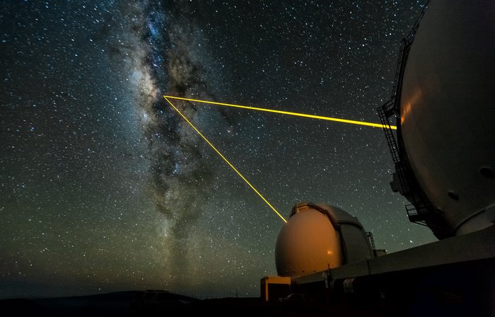 Laserstrahlen erzeugen am Keck Observatory einen künstlichen Stern. Keck Observatory vor dem Nachthimmel. Zwei Laserstrahlen erzeugen einen künstlichen Stern.