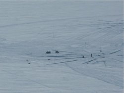 Foto. Auf einer weißen Eisfläche sind Stangen und Rohre zu erkennen.