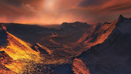 In rötliches Licht getauchte, vereiste Gebirgslandschaft. 