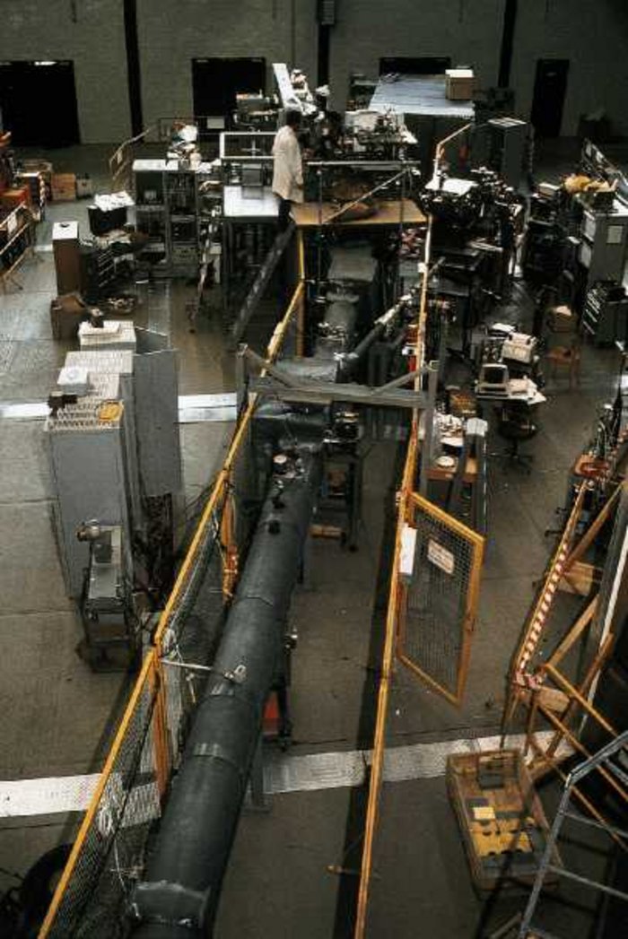 1980: Erster Strahl in der HASYLAB-Experimentierhalle Foto eines langen Stahlrohrs, an dessen Ende eine technische Apparatur aufgebaut ist.
