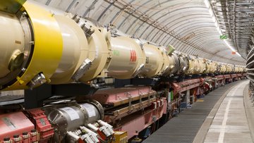 Entland eines Tunnels steht eine längliche technische Anlage, die aus runden Rohrenstücken zusammengesetzt ist.